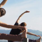 Nadine von naé yoga mit Chantal von Tada Yoga machen die Yoga-Pose seitliche Neigung am See in Uerikon